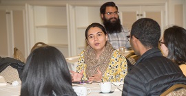 Student talking with other students at a round table during a Students of Color Dinner 