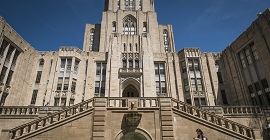 Student walking in front of base of Cathedral of Learning